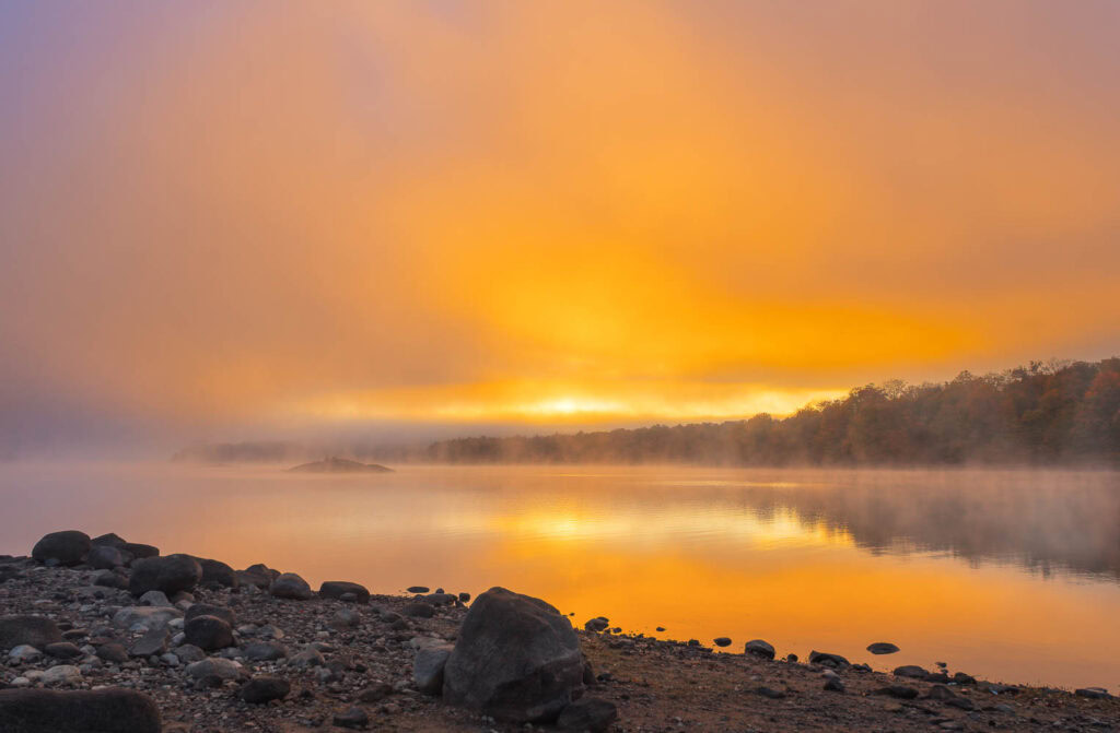 Foggy Morning on Indian Lake A beautiful orange-colored sunrise on the shore of Indian Lake in the Adirondack Mountains.