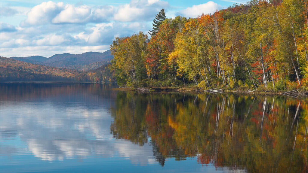 Adirondack Lake View Adirondack lake in the fall with beautiful autumn reflections and forested mountains in the background.